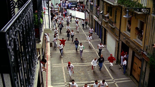 高角度放大人群在城市街道上跑步/奔牛/潘普洛纳，西班牙视频下载