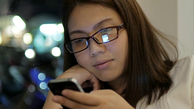 女性戴着眼镜在休闲时间使用智能手机，生活方式概念，4k(超高清)视频素材