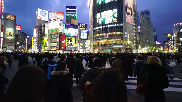 周六傍晚，镜头正穿过涩谷十字路口前往涩谷中心。拍摄城市夜景和十字路口的行人。视频下载