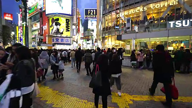 周日傍晚，镜头正穿过涩谷十字路口前往涩谷中心盖街。捕捉城市夜景和步行时的行人。视频素材