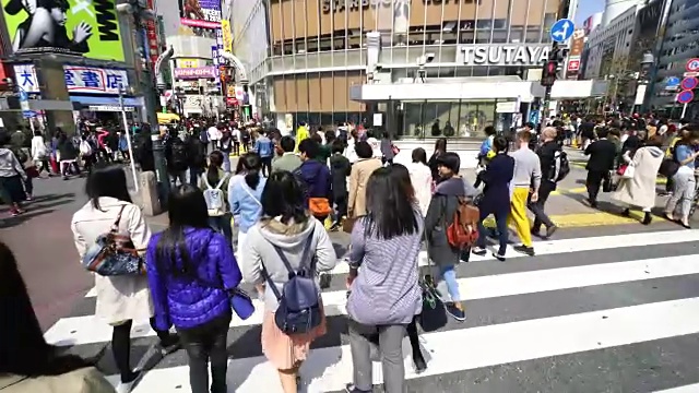 镜头正穿过涩谷十字路口前往涩谷中心。旋转相机捕捉城市景观和行人在十字路口。视频素材