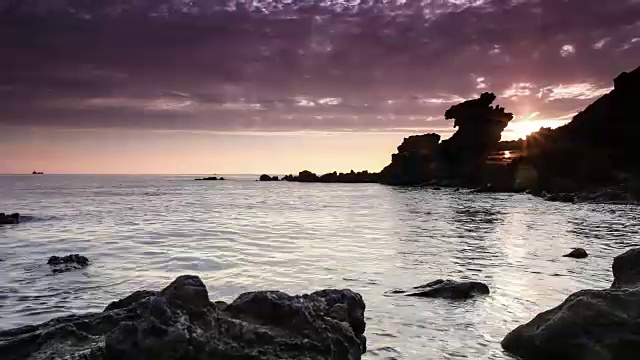 济州岛永渡湾海滩的永美日石(旅游景点)的日出照片视频素材