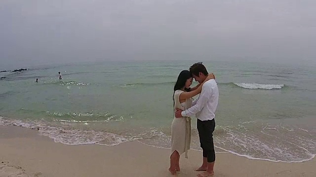 一对新婚夫妇在济州岛海滩摆姿势视频素材