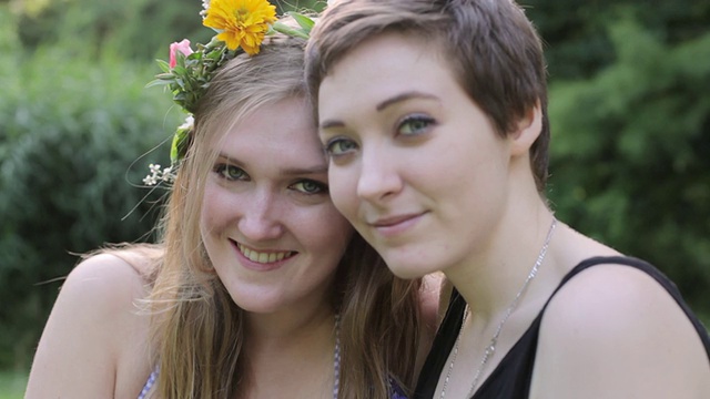 “两名朋友戴着花圈在夏日微笑的室外/德国柏林”视频素材