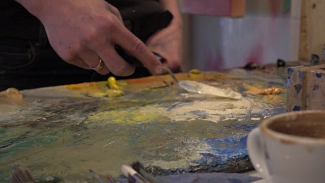 女艺术家在绘画前在工作室混合颜料视频素材