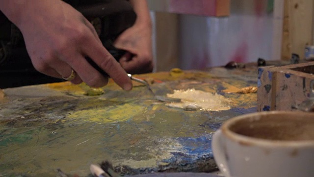 女艺术家在绘画前在工作室混合颜料视频素材