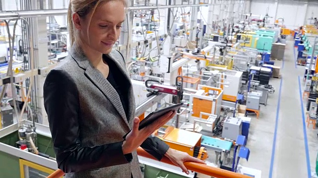 美丽的女商人在未来的工厂里研究平板电脑视频下载