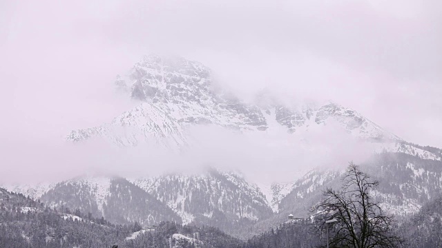 冬天，雾在雪山周围移动。视频下载