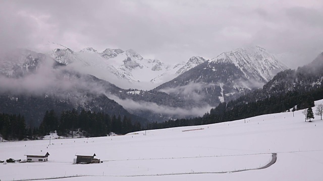 云落在雪山上。人们在底部滑雪和滑雪缆车。视频下载