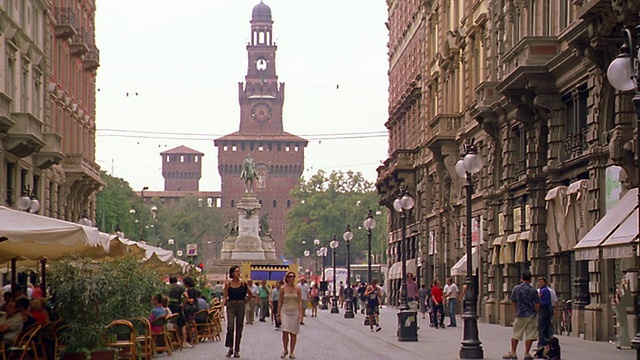 意大利米兰，PAN人走在咖啡馆/教堂+雕像的街道上视频下载