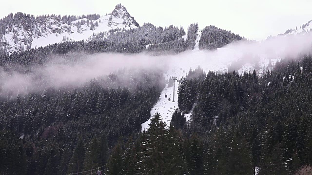 在雪山中上下移动的滑雪缆车。视频下载