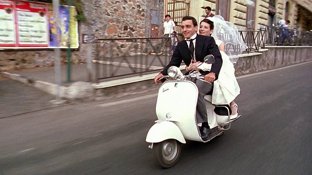 跟踪拍摄新娘和新郎在意大利罗马的城市街道上骑摩托车视频下载