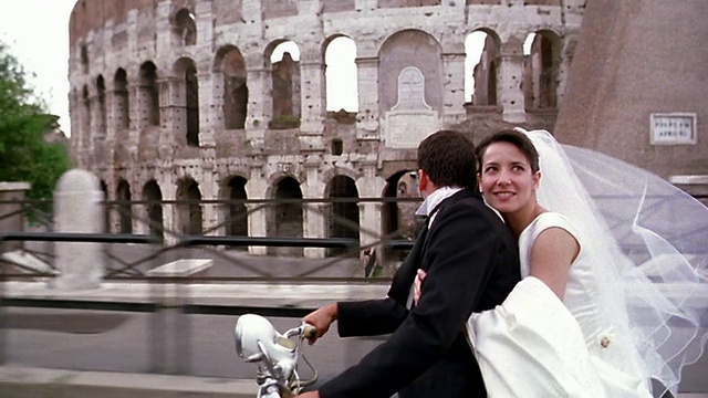意大利罗马，新娘骑着摩托车经过罗马竞技场时亲吻新郎视频素材