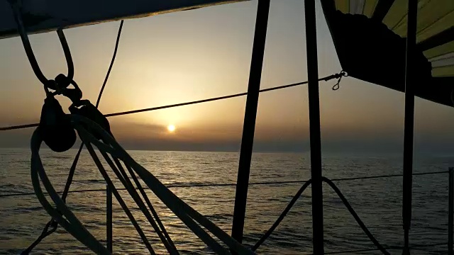 日落通过一个运动帆船的索具视频素材