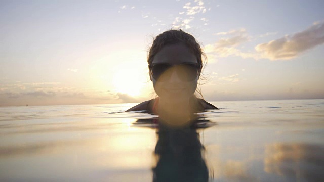 在夕阳下享受大海的女人亲吻着相机视频下载