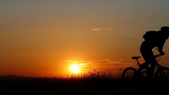 日落美景和骑山地车视频素材
