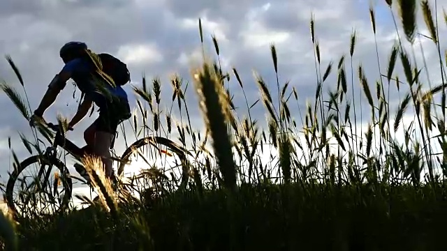 骑自行车的人有乐趣在顶部日落慢动作视频素材