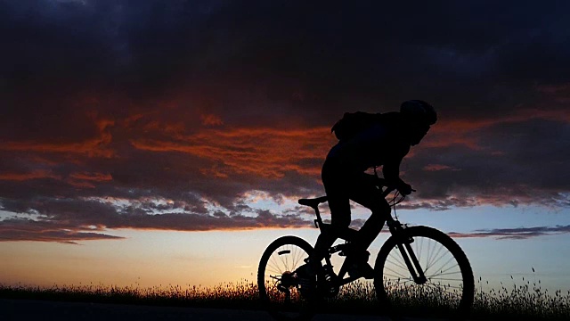 日落时的云景和山地自行车慢动作视频下载