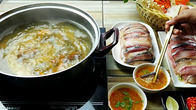 吃泰国菜的亚洲人。在一锅热水中放入鱼肉视频下载