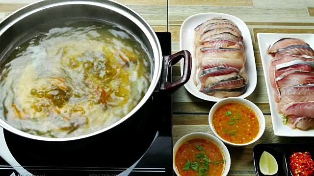 吃泰国菜的亚洲人。在一锅热水中放入鱼肉视频下载