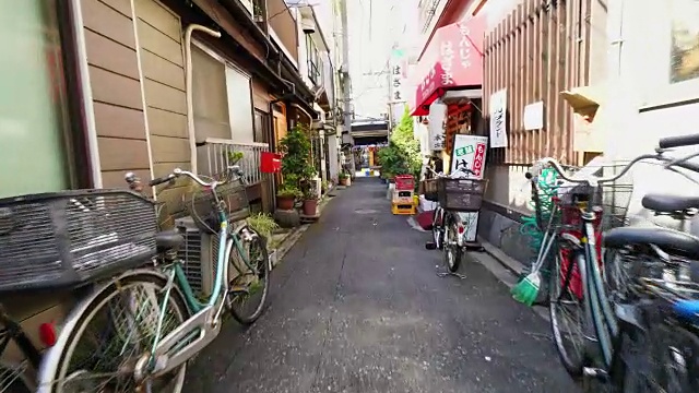 镜头捕捉到了东京城中心筑岛居民用盆花布置的狭窄小巷。在小巷的两侧，有日本传统的长屋风格的房子。视频下载