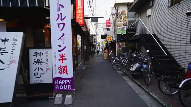 在东京神乐坂，行走的摄影机穿过神乐口，来到道久横町狭窄的小巷。在小巷的两边有许多餐馆、酒吧和商店。视频素材