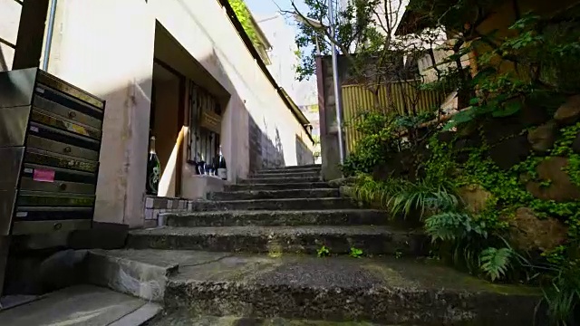镜头沿着东京神乐坂狭窄的石头楼梯走上去，这条小巷被建筑物包围着。在小巷的两边有一些餐馆和酒吧。视频素材