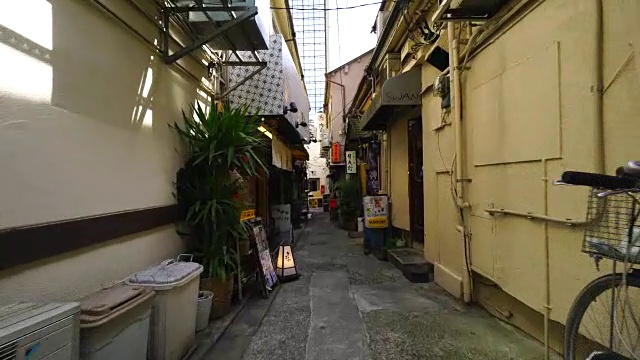 在东京神乐坂的一条狭窄巷子里，行走的摄像机。在小巷的两边有许多餐馆、酒吧和商店。视频素材