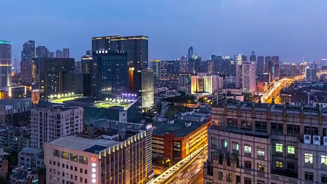 随着夜幕降临，城市灯火通明，高速公路和立交桥上的车流依稀可见杭州的天际线视频素材