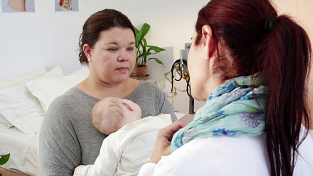 肩膀上射女儿科医生与抱着新生儿的母亲谈话视频下载
