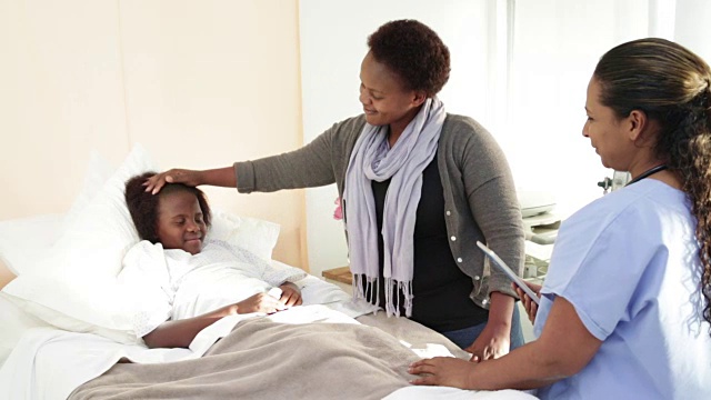 女医生与非洲母亲和女儿在医院视频下载