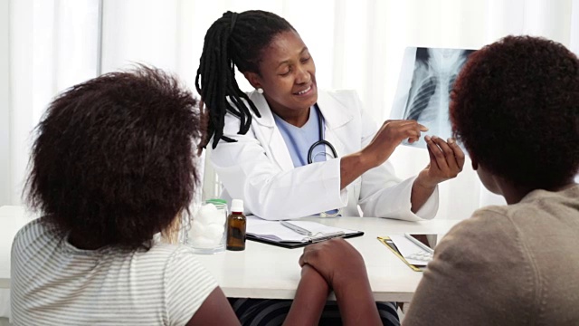 非洲女医生与母亲和女儿讨论胸部x光视频素材