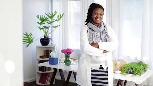 自信的非洲女医生站在她的桌子前视频下载
