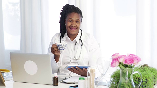 非洲女医生喝她的茶和微笑的镜头视频下载