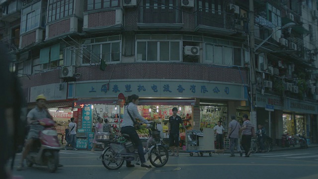 WS SLO MO拍摄中国上海狭窄街道上的小商店和餐馆，还有经过的自行车和摩托车视频下载