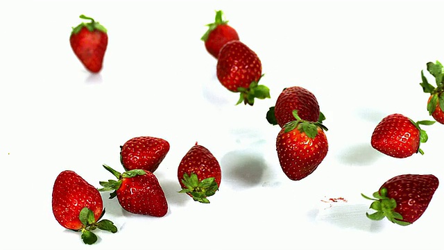 草莓，草莓，水果滚动在白色背景，慢动作视频素材
