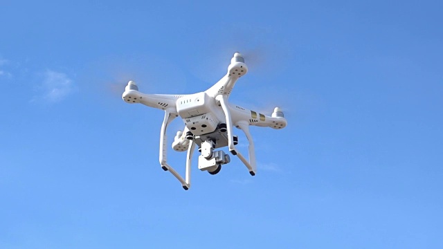 带数码相机的无人机四架直升机在蓝天翱翔视频下载