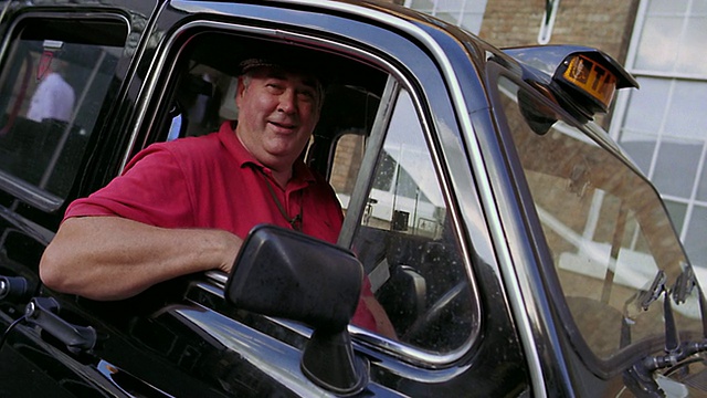 摄影车拍摄肖像出租车司机在黑色出租车礼帽+微笑/伦敦，英国视频下载