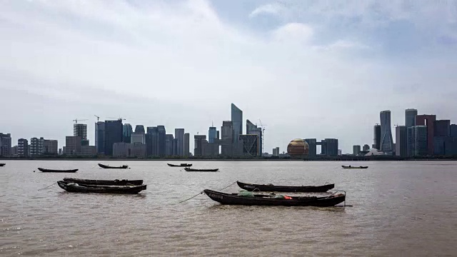 中国杭州，渔船在河上与摩天大楼相对视频下载