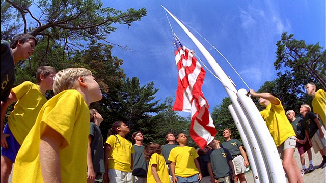 鱼眼低角度一群孩子看着女孩在夏令营中升起美国国旗视频下载