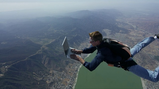 跳伞者在自由落体状态下用笔记本电脑工作视频下载