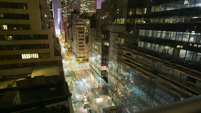 运动控制延时在曼哈顿市中心的建筑物倾斜与宽镜头在晚上。视频素材