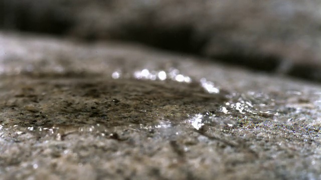 水滴落在花岗岩上。视频下载