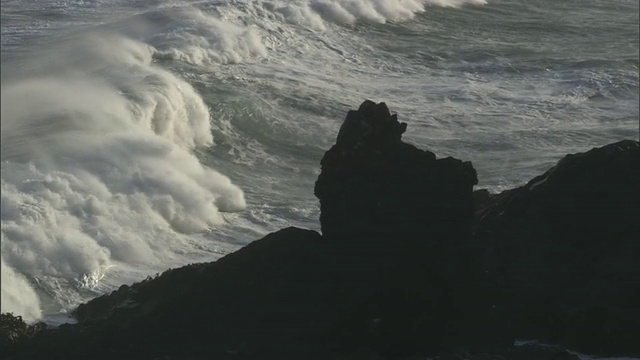 在新西兰，暴风雨的海浪翻滚到多岩石的海岸视频素材