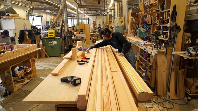 运动控制，上升的垂直起重机移动显示工人排队切割木片在定制木工车间视频素材