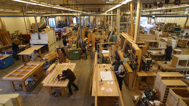 Aeriel视角的大型定制木工车间的地板，有许多工作站和工人可见视频素材
