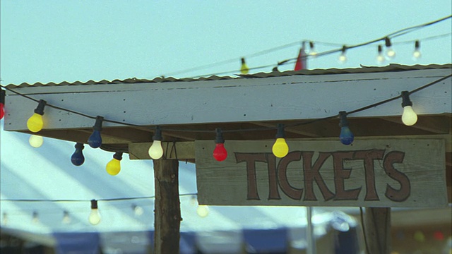 中等角度的票站与圣诞灯标志。在bg中可见帐篷。可能是牛仔竞技表演，马戏表演，狂欢节，或者集市。视频下载