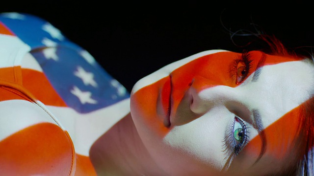 近距离慢动作拍摄的美国国旗投影在妇女的脸/雪松山，犹他州，美国视频下载