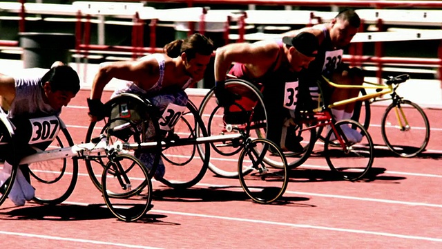 过度曝光选择性聚焦慢动作PAN组男子在轮椅上赛道上比赛视频下载