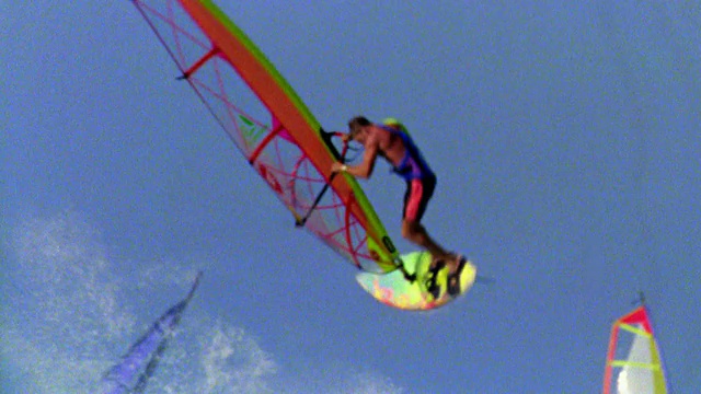 慢动作男性风帆冲浪者跳离海浪，在空中翻转+消灭/夏威夷视频素材